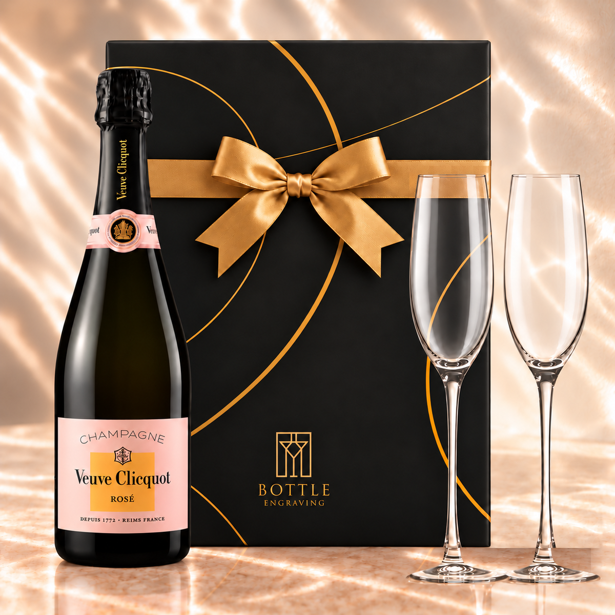 Veuve Clicquot Rosé Champagne gift set with two champagne flutes and a black Bottle Engraving gift box tied with a gold bow.
